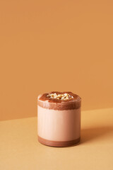 Protein chocolate cocktail drink in glass on brown background