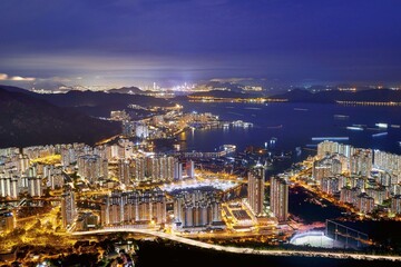 Fototapeta premium night view of a city skyline with illuminated buildings Hong kong harbour view