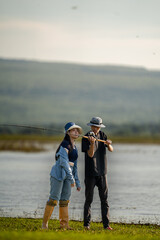 Obraz premium A man and a woman are standing by a body of water