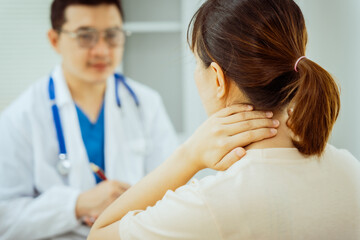 Fototapeta premium A male Asian pediatrician in a white lab coat sits at his desk, warmly greeting a middle-aged pregnant woman for a prenatal consultation, offering care and support in a clinical setting.