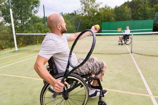 Active wheelchair users enjoying a game of tennis on an outdoor court
