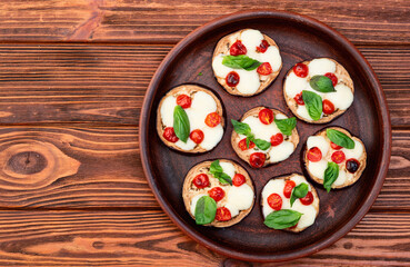 Italian mini pizza . Aubergine (eggplant ) with mozzarella cheese and basil . On rustic background