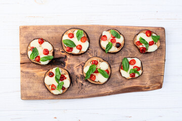 Italian mini pizza . Aubergine (eggplant ) with mozzarella cheese and basil . On rustic background