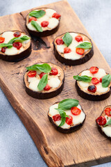 Italian mini pizza . Aubergine (eggplant ) with mozzarella cheese and basil . On rustic background