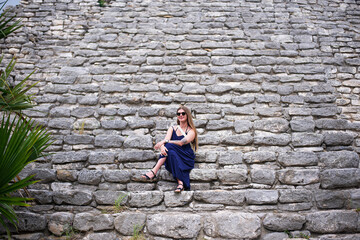 woman tourist in complex of mayan pyramids with wide impressive steep stairs in ancient city lost in the tropical jungle of Yucatan