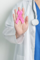 Obraz premium Pink October Breast Cancer Awareness month, woman doctor with pink Ribbon in hospital for support people life and illness. National cancer survivors month, Mother and World cancer day concept