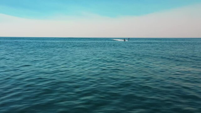 Low aerial view over ocean wave flying towards jetski and hydro foil in Sydney