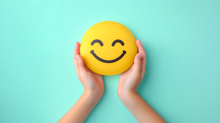 Children's hands holding positive smiley face isolated on light green background. Child health and protection concept.