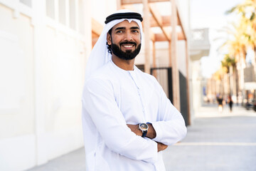 Traditional arab man wearing emirati kandura outdoors - Handsome middle-eastern adult male businessman portrait in the city