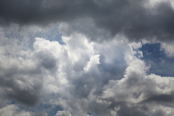 Fototapeta premium Gray-blue clouds in the sky after a storm, light on gray-blue clouds in the sky, celestial flower of clouds in the blue sky