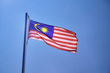 Malaysian Flag Waving Against the Blue Sky
