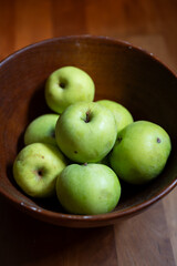 Ripe, green garden apples in a wooden bowl, no people