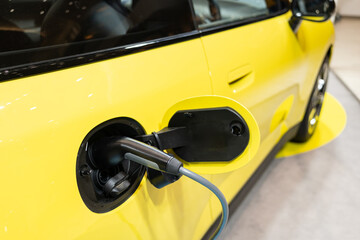 EV Car or Electric car at charging station with the power cable supply plugged. EV charging station for electric car in concept of green energy and eco power produced.