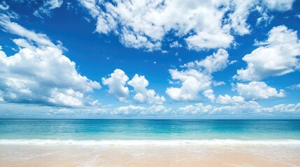 Fototapeta premium Blue sky with abstract white clouds over a tropical beach. Perfect for a summer escape.