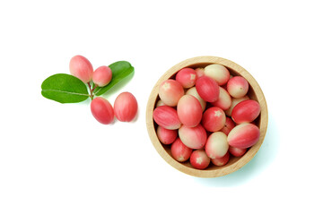 Group of Bengal-currants, or Carandas-plum or Karanda in wooden bowl and outside with green leaves isolated on white background with clipping path. Top view. Flat lay.