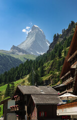 Matterhorn Mountain rises majestically over traditional Swiss chalets in Zermatt under a clear blue sky