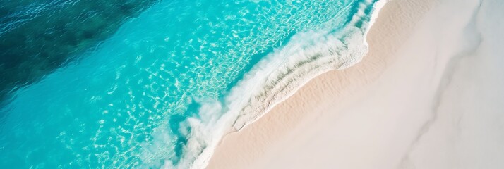 Fototapeta premium An aerial perspective showing stunning turquoise waves flowing onto the clean sandy shore, presenting an idyllic and refreshing coastal scene.