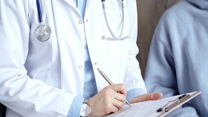 Doctor consulting patient with clipboard while making medical notes on a clipboard. Medicine concept