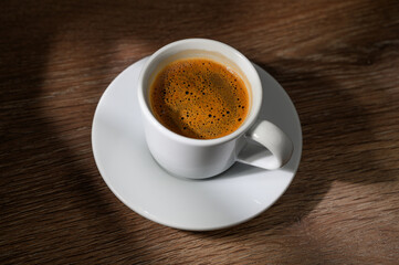 Traditional Turkish coffee in traditional silver cup on wooden table