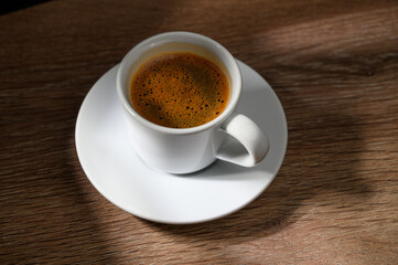 A cup of coffee on a wooden table.