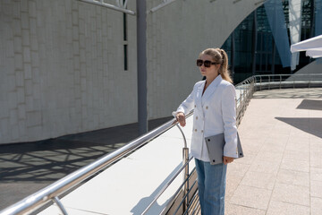 blonde woman in a suit doing business walking down the street