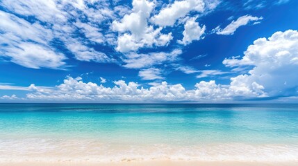 Obraz premium Serene tropical beach with a blue sky and white clouds. Perfect for a summer escape.