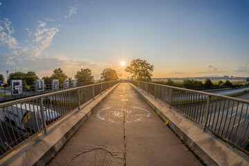Fototapeta premium Picture over a highway bridge to the setting sun