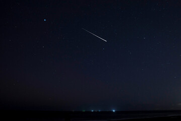 Beautiful meteors in the night sky over Latvia. Night landscape with shooting stars. Falling...