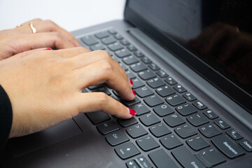 women's hand are typing on laptop keyboard