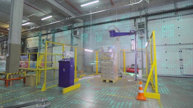 Packaging boxes with products in plastic film at the factory. A special machine wraps boxes in polyethylene film