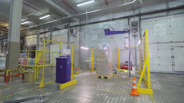 The concept of automatic packaging of goods in film. Packing boxes in film at the factory. Visualization of a modern factory