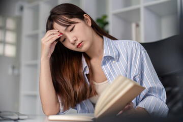 Young Student Studying Online at Home, Concentrating on a Book, in a Modern Home Office Setting