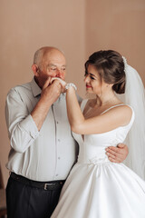 A man and a woman are embracing each other. The man is touching the woman's nose. The woman is wearing a wedding dress