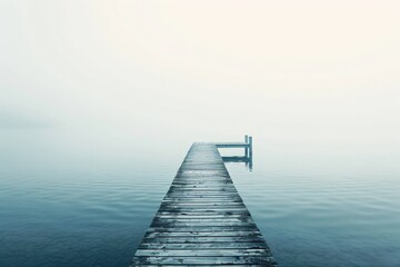 Fototapeta premium A serene and tranquil image of a wooden pier extending into calm, misty waters, evoking a sense of peace and solitude in a simple, minimalist setting.