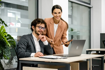 Professional team meeting in the office. Leader discussing investments and digital project management with board members. Ideal for showcasing teamwork and strategic planning.