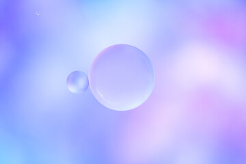 Oil drops in water on lilac gradient background. Macro photo