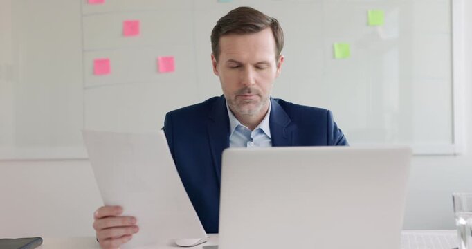 Businessman working with laptop and documents at office 