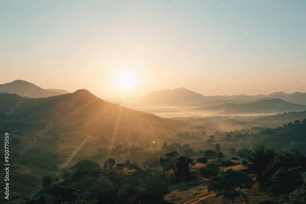 Poster the sun rises over distant mountains, casting a glow across a hazy sky and creating a dreamy, ethere
