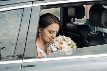 A bride is sitting in a car with a bouquet of flowers in her lap. She is looking out the window, possibly lost in thought or admiring the scenery. Concept of romance and anticipation