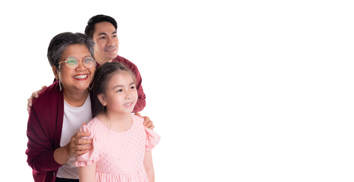 Joyful multigenerational family portrait featuring a grandmother, father, and young girl, symbolizing family unity and love against a clean white background. They are looking to copy space with happy