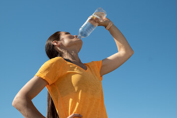 Low angle view of female sportsman drinking water from bottle