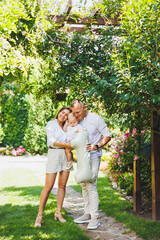 Fototapeta premium Loving parents mom and dad celebrate one year of their son in nature. Happy family hugging their little son.