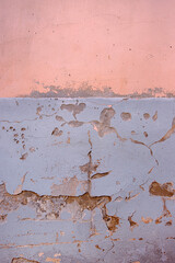 Weathered wall with peeling paint in pastel pink and gray.  Ideal for backgrounds, urban photography, grunge textures, vintage aesthetics, creative design elements. Copy space