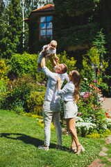 Obraz premium Mom and dad in nature with their one-year-old son. Happy family with little son in nature.