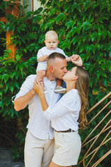 Mom and dad in nature with their one-year-old son. Happy family with little son in nature.