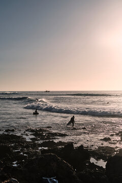 Surfisti che si apprestano ad affrontare le onde al tramonto.