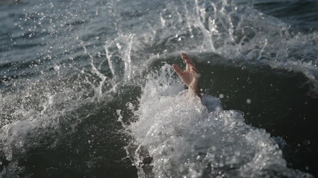 Person's hand comes out of the water