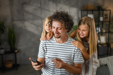 daughters buy online with their dad on mobile phone and credit card