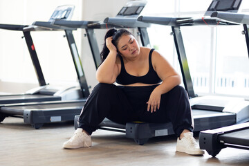 Tired fat asian woman. beautiful young chubby overweight woman wearing sporty fitness clothes doing...