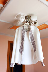 An embroidered wedding dress hangs on the lamp.